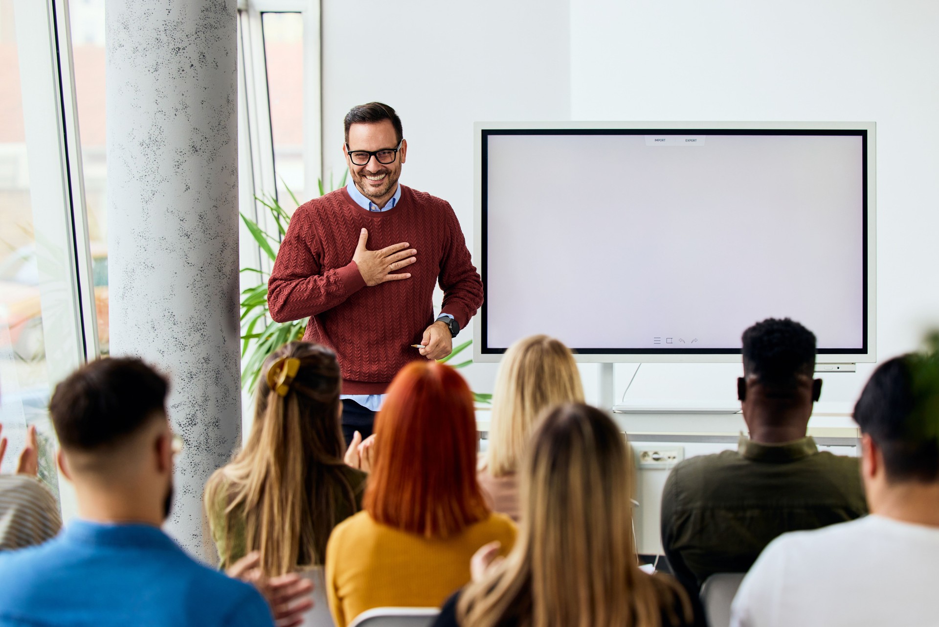 Man Giving a Presentation to a Group in a Modern Office