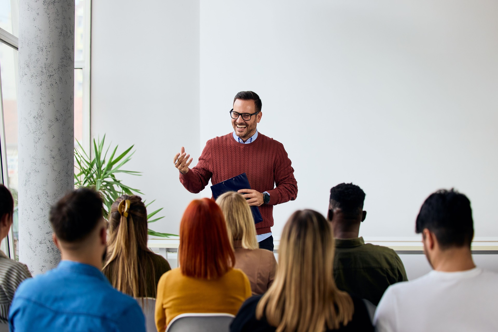 Confident Speaker Addressing a Diverse Group in a Modern Classroom Setting