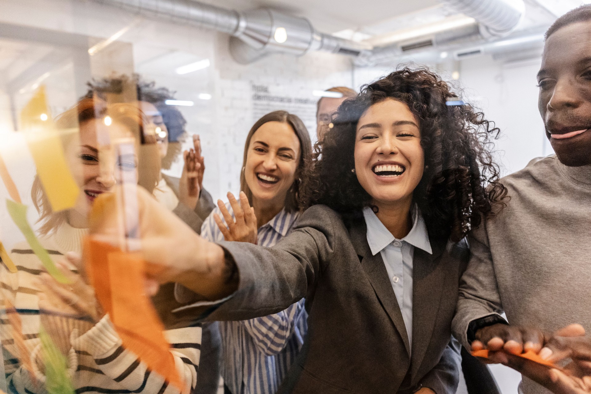 Coworkers are brainstorming and sharing ideas on sticky notes in coworking space